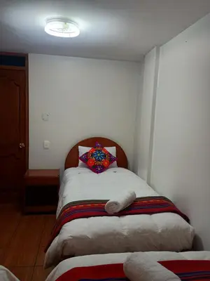 a bedroom with a bed with a pillow on it at Hotel TIKA AYNA Cerca a la plaza de Armas CUSCO in Cusco