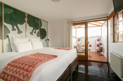 a bedroom with a large bed and a balcony at Andenes in Cusco