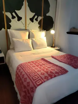 a bedroom with a bed with a red and white blanket at Andenes in Cusco