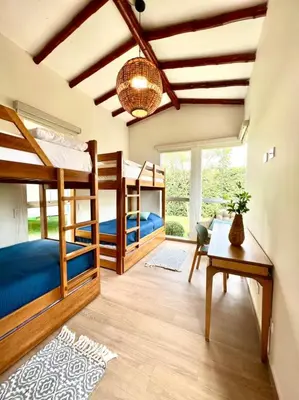 a room with four bunk beds and a table at Kuyayky Lodge in Lima