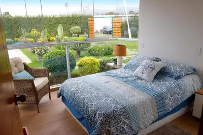 a bedroom with a bed and a large window at Kuyayky Lodge in Lima