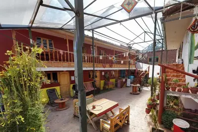 an outdoor patio with a wooden table and benches at KanchayKillaWasi in Chinchero