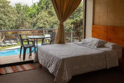 a bedroom with a bed and a balcony with a table at Hotel Rumi Wasi in Lunahuaná