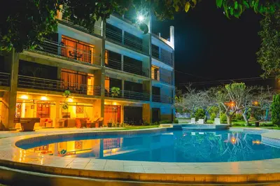 a swimming pool in front of a building at night at Hotel Rumi Wasi in Lunahuaná
