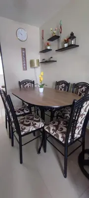 a dining room table and chairs with a table and a clock at Casa Club Vacacional in Ica