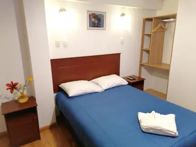 a small bedroom with a blue bed and a shelf at El Ave Azul Boutique Hotel Cusco in Cusco