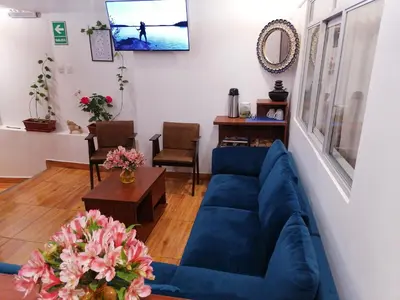 a living room with a blue couch and a table at El Ave Azul Boutique Hotel Cusco in Cusco