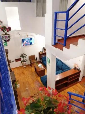 a living room with a blue couch and stairs at El Ave Azul Boutique Hotel Cusco in Cusco