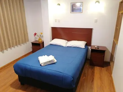 a bedroom with a blue bed with two towels on it at El Ave Azul Boutique Hotel Cusco in Cusco