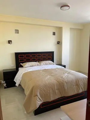 a bedroom with a large bed with a wooden headboard at Casa Galarza in Huancayo