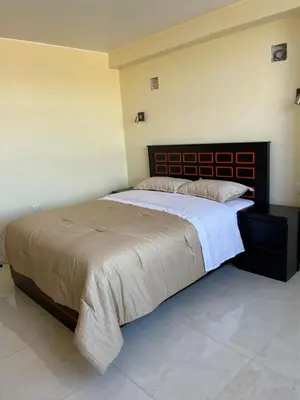 a bedroom with a large bed with a wooden headboard at Casa Galarza in Huancayo