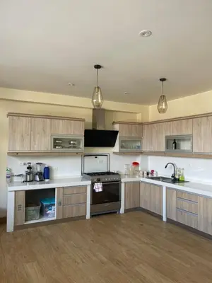 a kitchen with wooden cabinets and white counter tops at Casa Galarza in Huancayo
