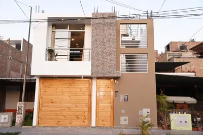 a house with a wooden garage door at Departamento Hermoso en Residencial - Huacachina in Ica