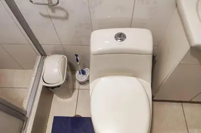 a small bathroom with a toilet and a trash can at Depawanka 1 departamento amoblado in Huancayo