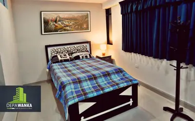 a small bedroom with a bed with a plaid blanket at Depawanka 1 departamento amoblado in Huancayo