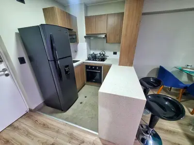 a kitchen with a refrigerator and a table and chairs at Apartamento estreno céntrico y moderno in Lima