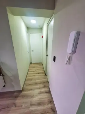 a hallway with a door and a television on a wall at Apartamento estreno céntrico y moderno in Lima
