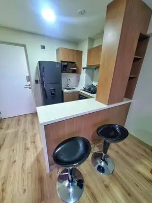 a kitchen with two black stools in front of a counter at Apartamento estreno céntrico y moderno in Lima