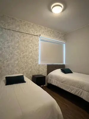 a room with two beds and a window with a window shade at MLA apartments - Larcomar in Lima