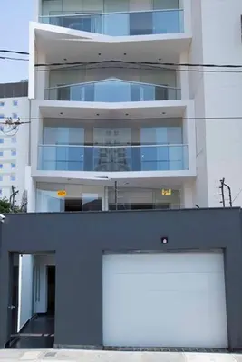 a building with two white garage doors in front of it at MLA apartments - Larcomar in Lima