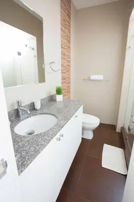 a white bathroom with a sink and a toilet at MLA apartments - Larcomar in Lima