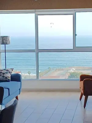 a living room with a large window view of the ocean at Stylish New Apartment with stunning Ocean View near Miraflores in Lima