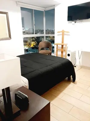 a bedroom with a black bed with a view of a city at Stylish New Apartment with stunning Ocean View near Miraflores in Lima