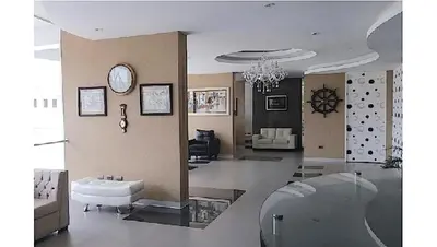 a living room with a couch and a clock on the wall at Stylish New Apartment with stunning Ocean View near Miraflores in Lima