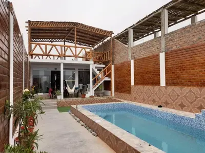 a house with a swimming pool and a brick wall at CASA PLAYA REFUGIO AZUL in Cerro Azul