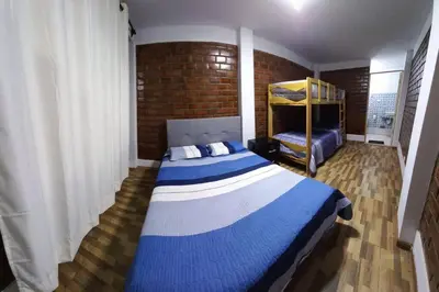 a bedroom with a blue and white bed and a brick wall at CASA PLAYA REFUGIO AZUL in Cerro Azul