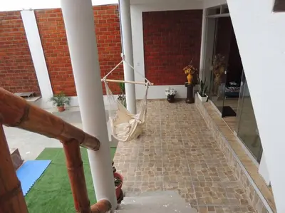a porch with a hammock hanging from a building at CASA PLAYA REFUGIO AZUL in Cerro Azul
