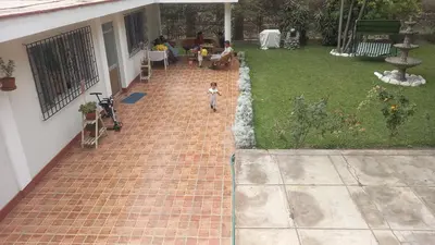a small child walking on a brick walkway in a yard at casa campestre marina in Chaclacayo