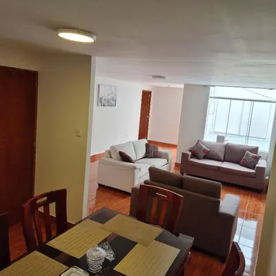 a living room with a couch and a table at Apart Hotel Cabral in Lima
