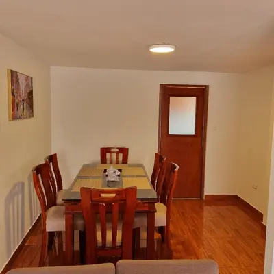 a dining room with a wooden table and chairs at Apart Hotel Cabral in Lima