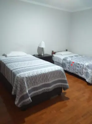 two beds sitting next to each other in a room at Apart Hotel Cabral in Lima
