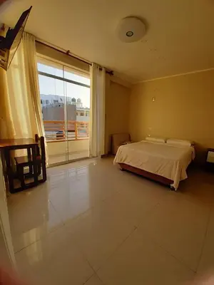 a bedroom with a bed and a large window at Hostel Willys House in Paracas