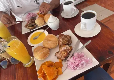 a wooden table with food and drinks and a plate of food at Hostel Willys House in Paracas