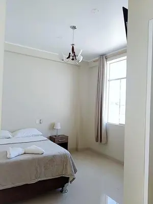 a bedroom with a bed and a ceiling fan at Hostel Willys House in Paracas