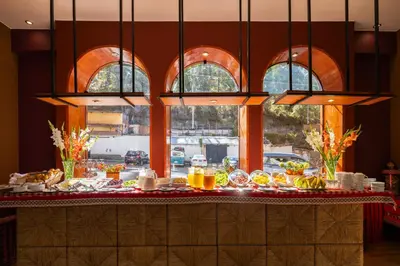a buffet with food on a table in front of windows at Mamasara Cusco in Cusco