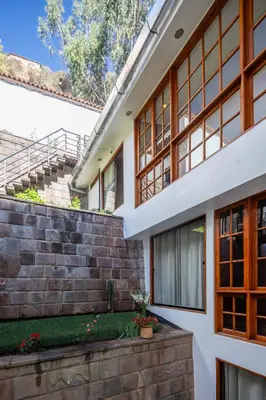 an external view of a house with a brick wall at Mamasara Cusco in Cusco