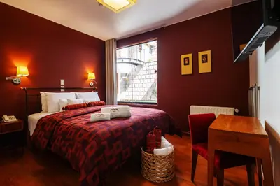a red bedroom with a bed and a window at Mamasara Cusco in Cusco