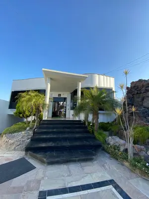 a building with stairs and palm trees in front of it at Embassy Beach in Pisco