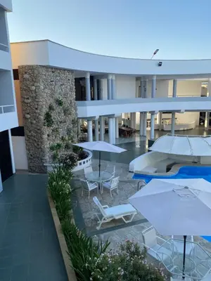 a courtyard with tables and umbrellas in a building at Embassy Beach in Pisco