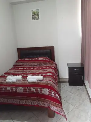 a bedroom with a bed with two towels on it at WAYRA APART HOTEL in Cusco