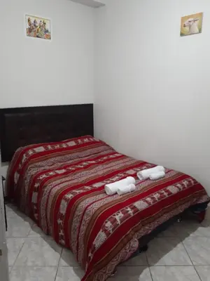 a bedroom with a bed with two towels on it at WAYRA APART HOTEL in Cusco