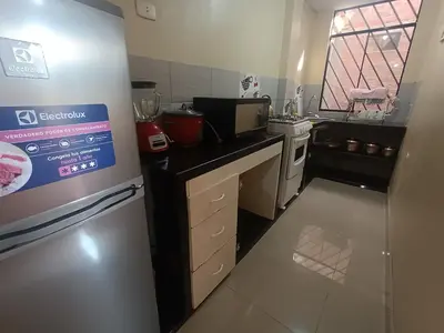 a small kitchen with a refrigerator and a stove at LUANA’S HOUSE in Ica