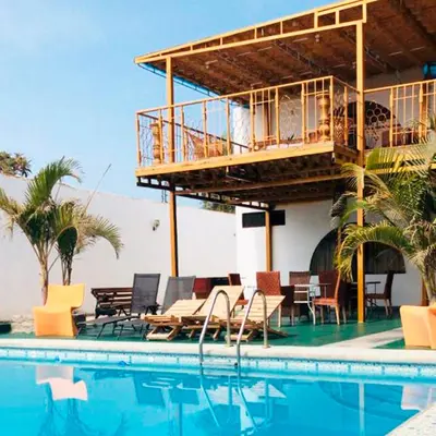 a house with a balcony and a swimming pool at Hotel Viñas del Sol Eterno in Chincha Alta