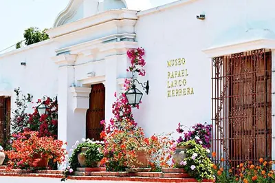 a white building with flowers on the side of it at Hermoso departamento en pueblo libre cerca al aeropuerto in Lima