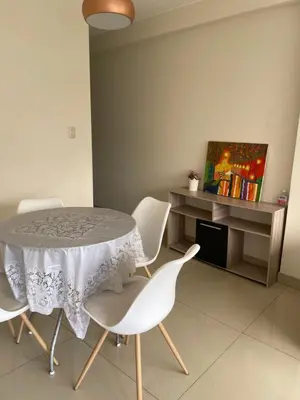 a dining room with a table and white chairs at Hermoso departamento en pueblo libre cerca al aeropuerto in Lima