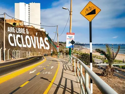 an empty street with a bike lane next to the beach at Beautiful apartment Near airport /cozy Oceanfront in Lima